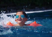 Petit garçon qui nage dans une piscine avec des brassards